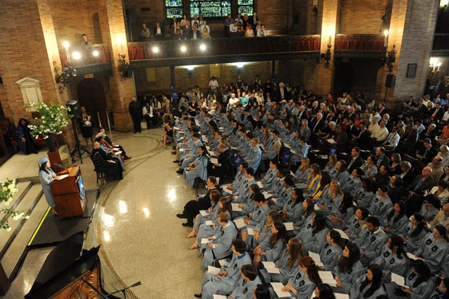 Baccalaureate Service in St. Paul's Chapel with a student speaking at the podium and hundreds of students listening in cap and gown. 