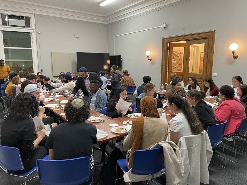 Students and religious leaders eating and learning together during the multi-faith fellowship.