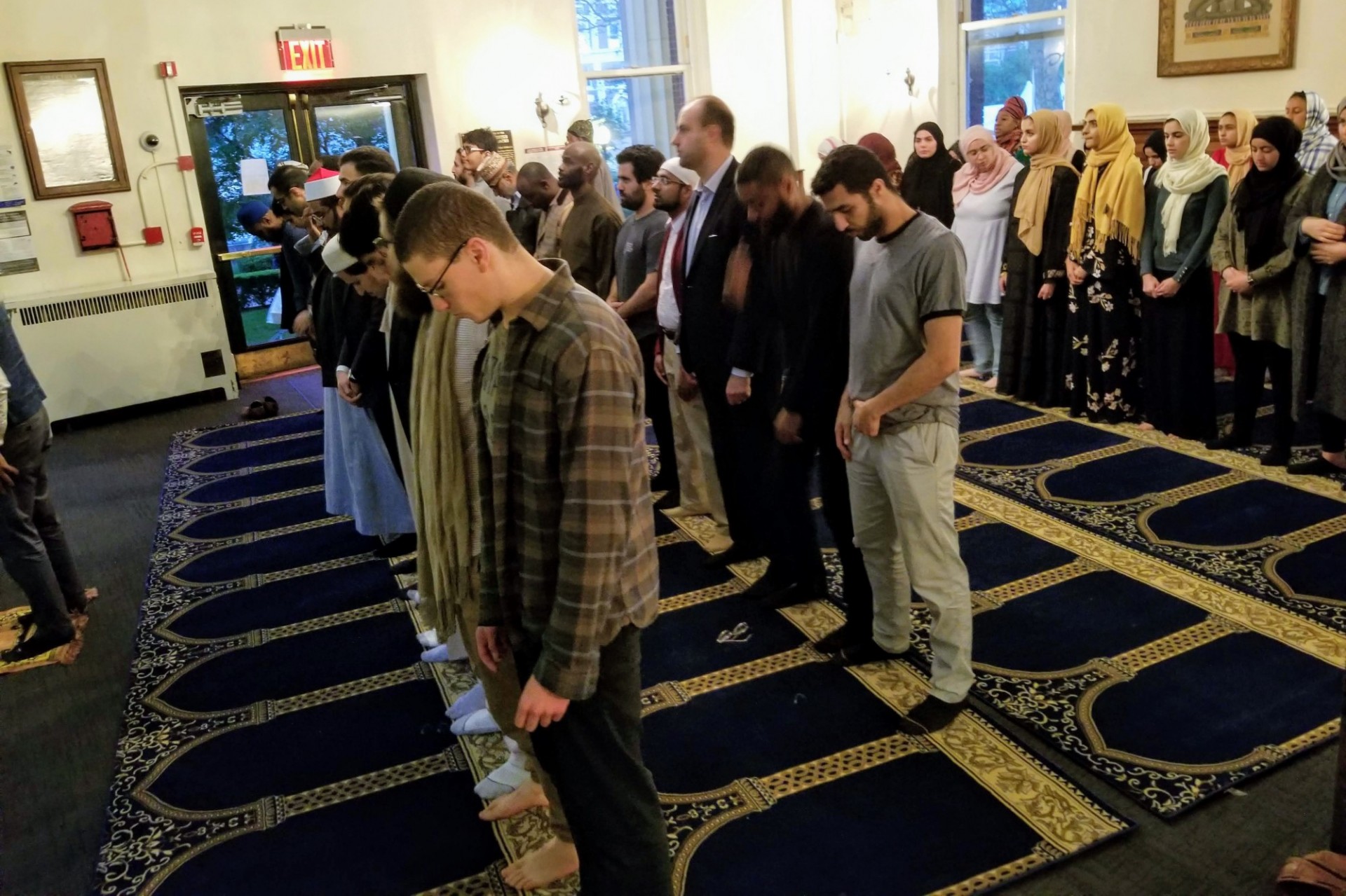Muslim students and community members praying in the lobby in Earl Hall.