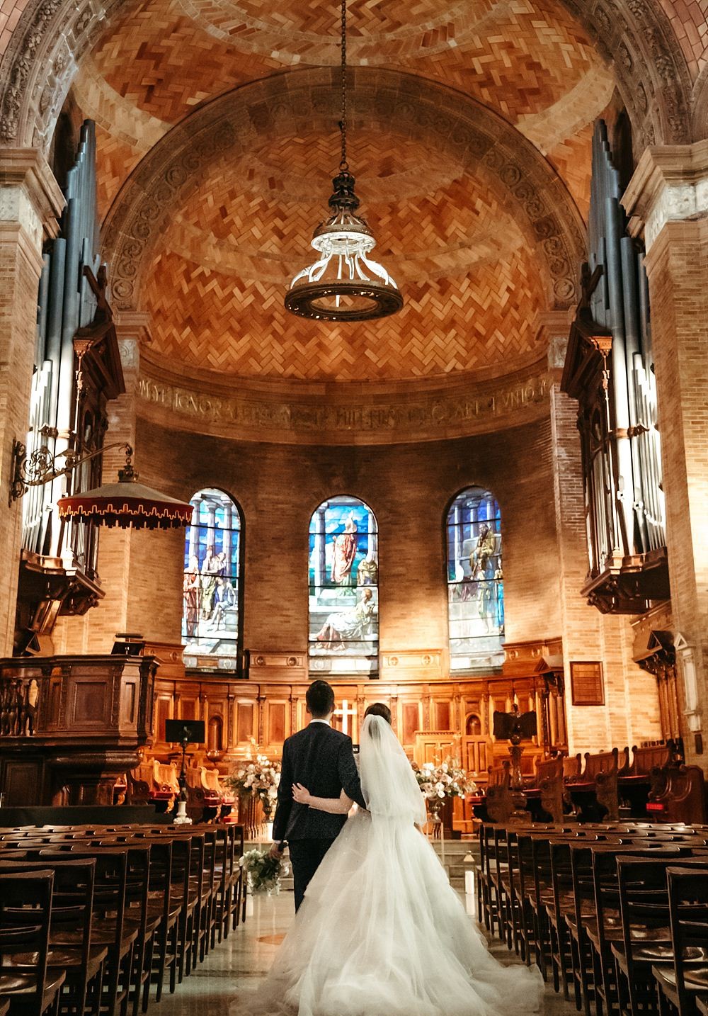 A newly married couple walking down the aisle in St. Paul's Chapel. 