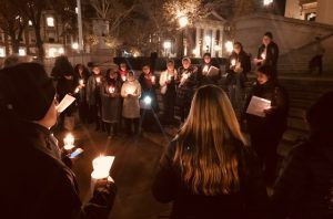 Students gathered on Low steps for a candlelit vigil at night.