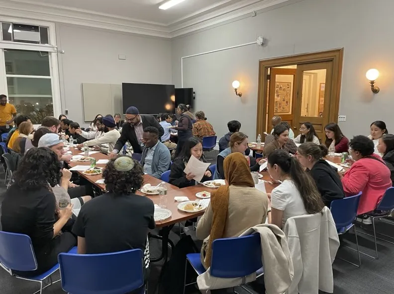 Students and religious leaders eating and learning together during the multi-faith fellowship. 